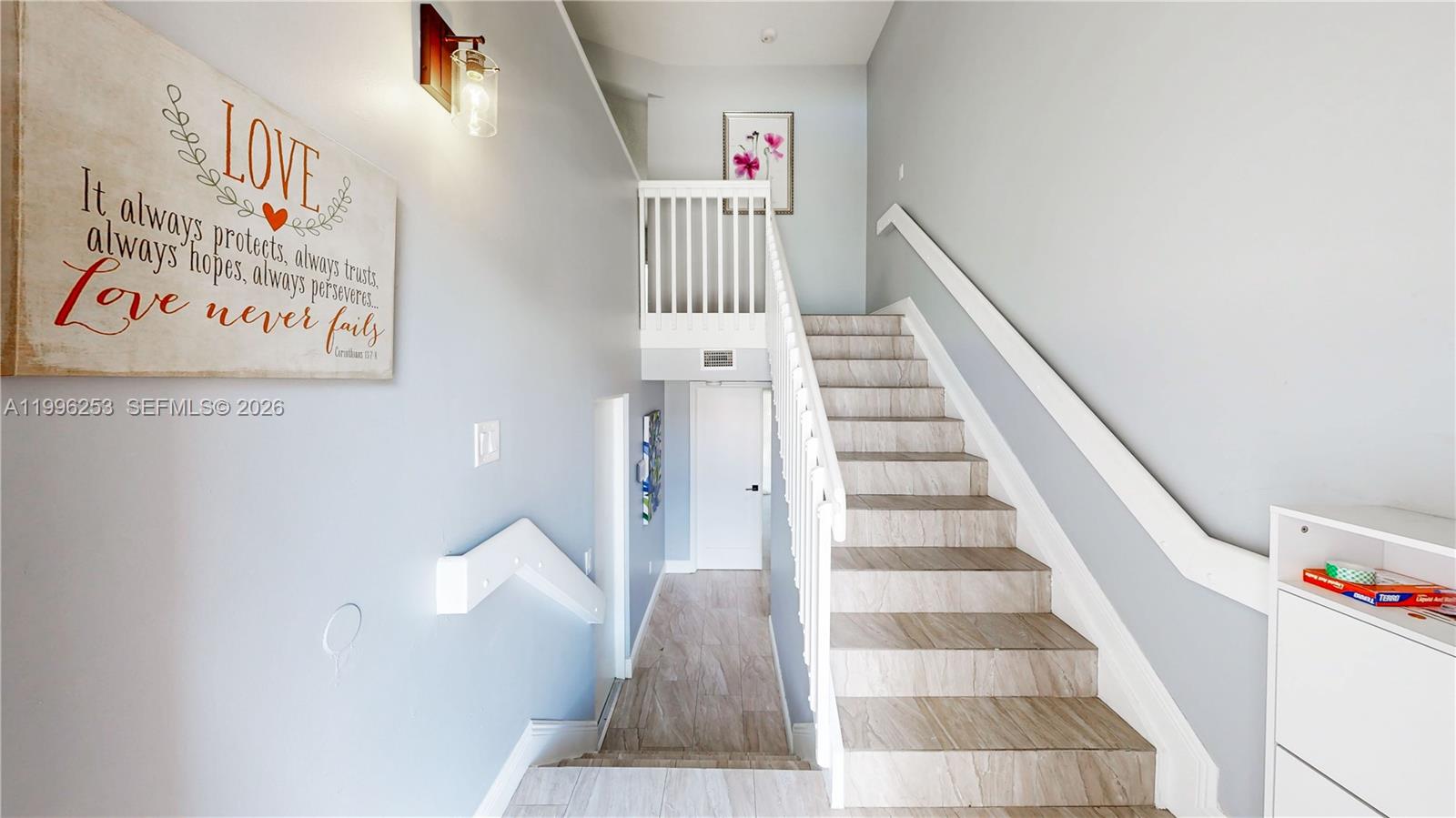 A staircase with wood-look tile steps leads to an upper landing in a light-walled hallway — 10101 SW 154th Cir Ct # 107, Miami FL 33196, MIAMI, FL