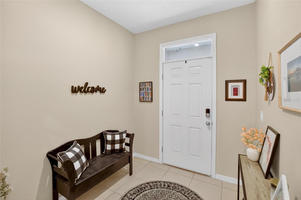 An entryway features a wooden bench, a console table, and a white front door — 3315 PLEASANT WILLOW COURT, BRANDON, FL
