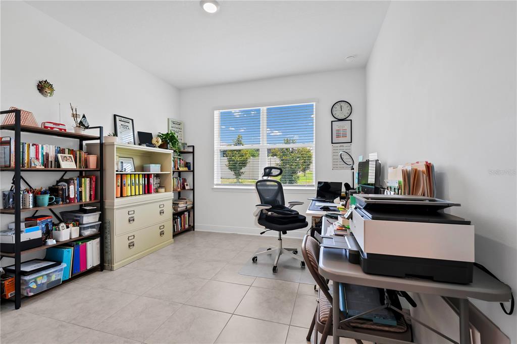 A home office features tiled floors, a desk with a printer, and multiple storage shelves — 4480 LIONS GATE AVENUE, CLERMONT, FL