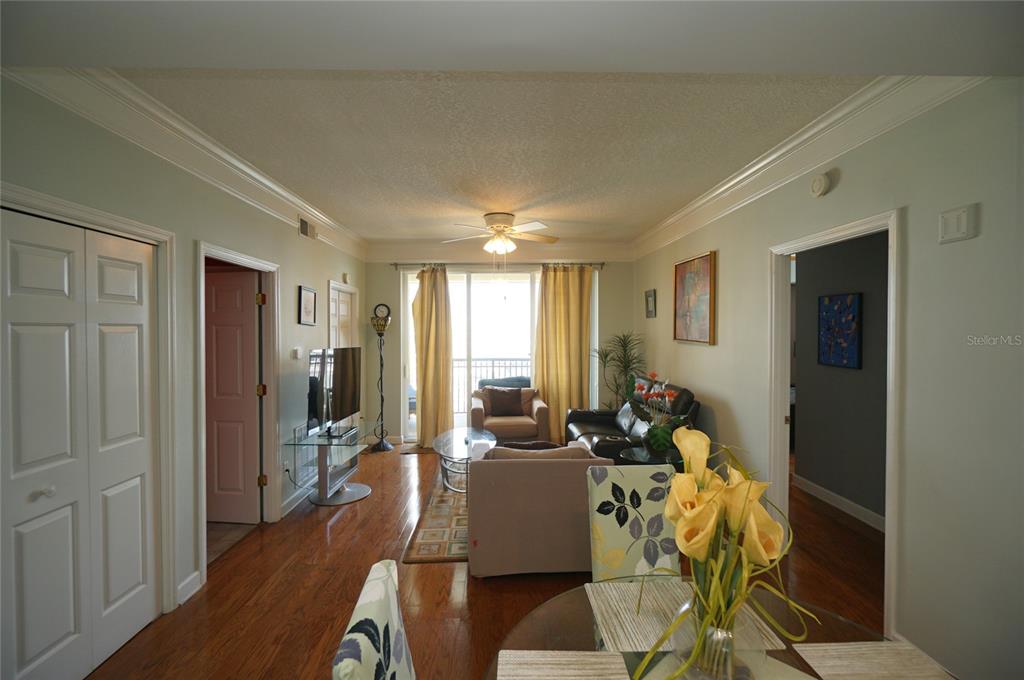 A living room with hardwood floors, a ceiling fan, and a sliding glass balcony door — 345 BAYSHORE BOULEVARD UNIT 1810, TAMPA, FL
