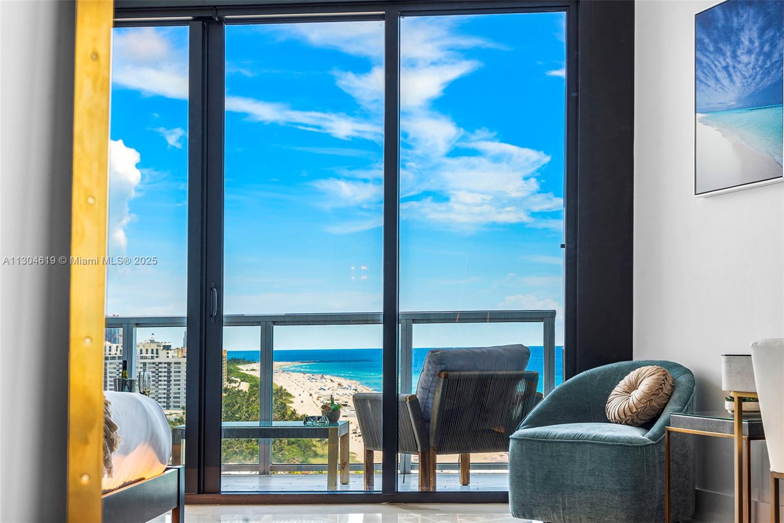 A bedroom features a large glass sliding door opening to a balcony overlooking the beach — 2201 Collins Ave, Miami Beach FL 33139, MIAMI BEACH, FL