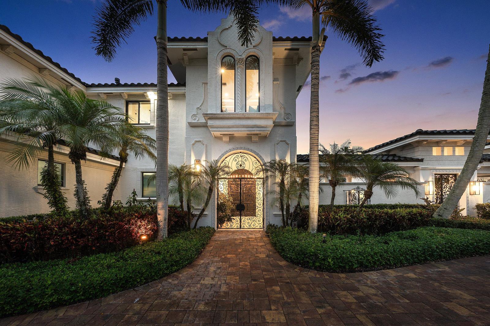 A white Mediterranean-style house with arched entry gates, palm trees, and a brick paver walkway — 3633 Carlton Place, Boca Raton FL 33496, BOCA RATON, FL