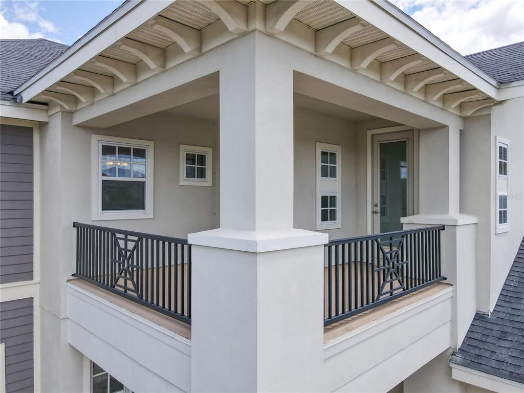 A corner balcony features white stucco walls, black metal railings, and a covered roof overhang — 9421 DUGARD COURT, ORLANDO, FL