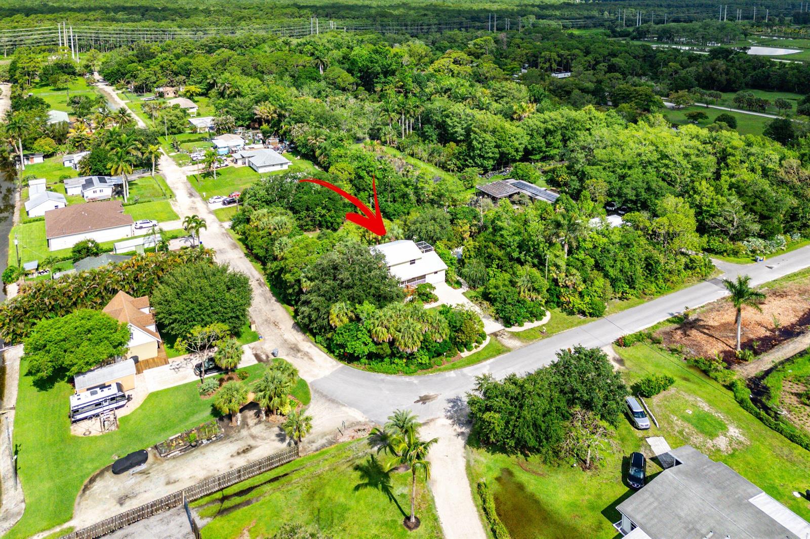 An aerial view shows a house surrounded by dense trees near a paved road — 7713 Park Lane Road, Lake Worth FL 33449, LAKE WORTH, FL