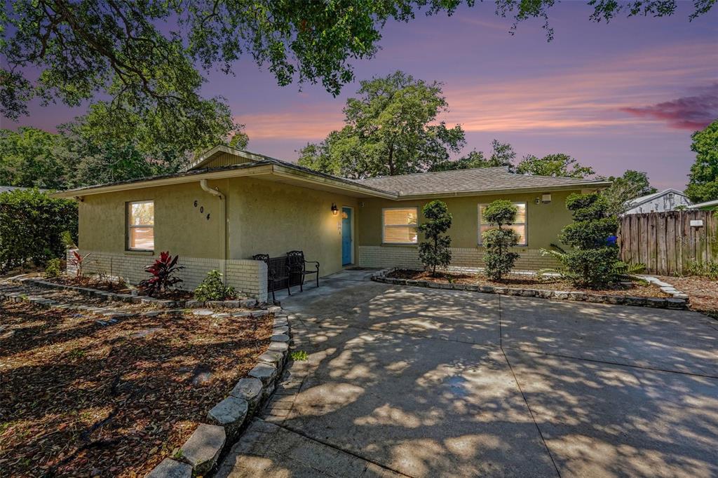 A single-story house with a light-colored stucco exterior, a concrete driveway, and a blue door — 604 LIMETREE DRIVE, OLDSMAR, FL