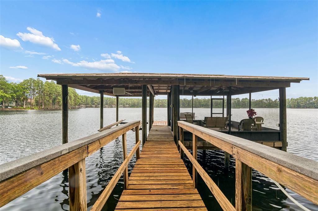 A bright living room features light wood floors, a tray ceiling, and sliding glass doors — 21105 LAKE VIENNA DRIVE, LAND O LAKES, FL