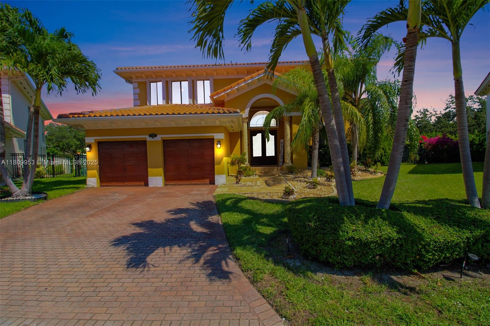 A two-story yellow house with a brick driveway, two garage doors, and palm trees — 7753 SW 193rd St, Cutler Bay FL 33157, CUTLER BAY, FL