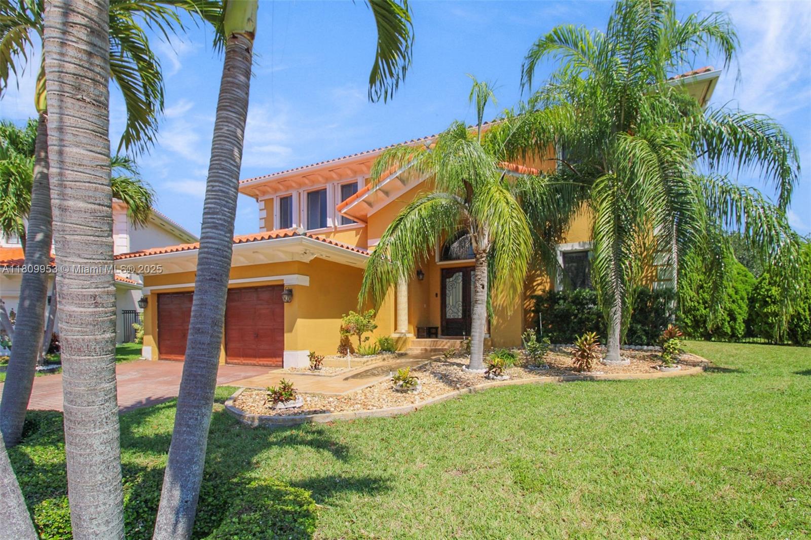 A two-story yellow house with a tile roof, two-car garage, and palm trees in front — 7753 SW 193rd St, Cutler Bay FL 33157, CUTLER BAY, FL