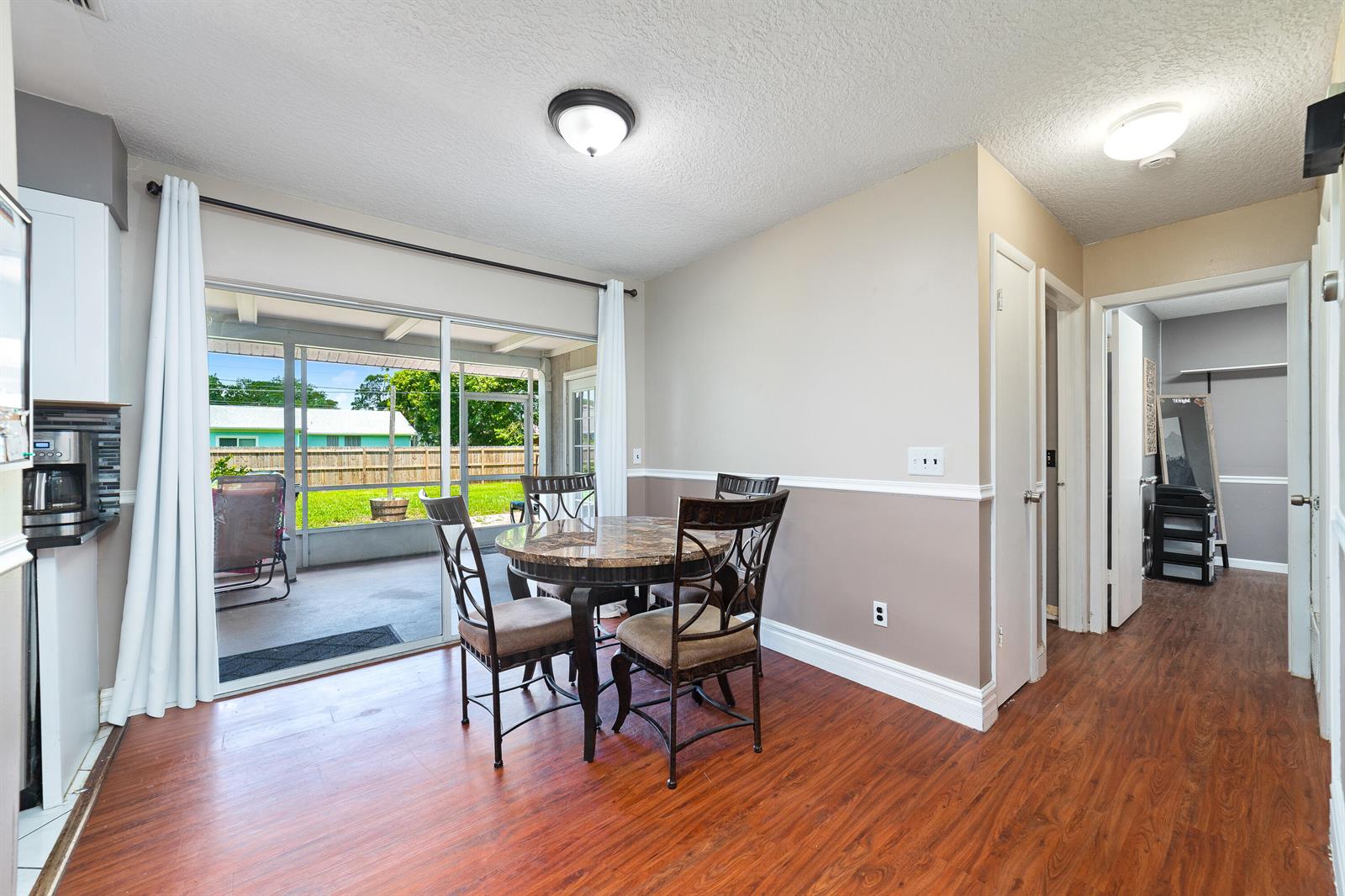 A dining area with a round table, wood-look flooring, and sliding doors to a patio — 542 Saunders Street, Sebastian FL 32958, SEBASTIAN, FL