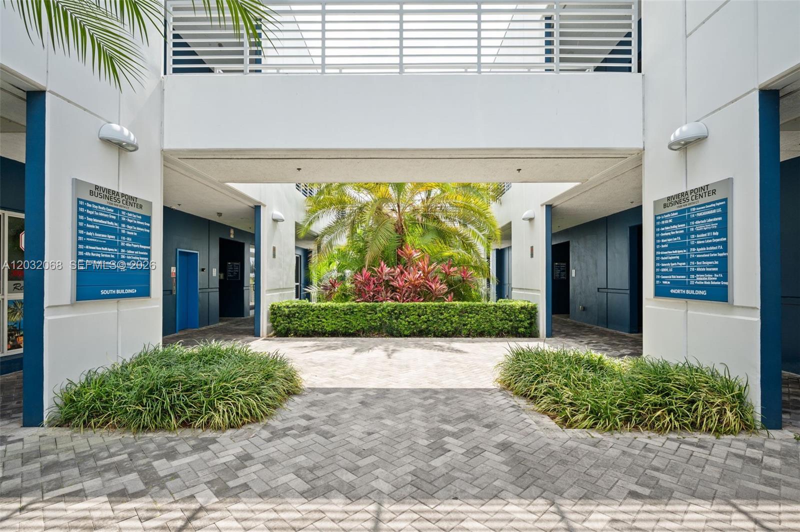 A courtyard with a central palm tree separates two business center buildings with directory signs — 1500 NW 89th Ct # 112, Doral FL 33172, DORAL, FL