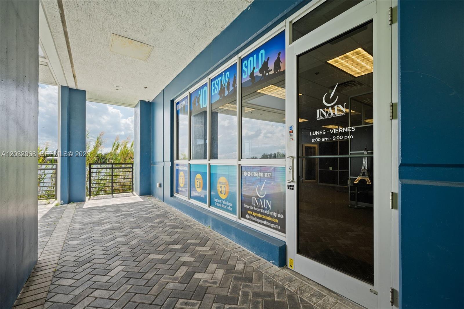 The exterior entrance of a commercial office space features blue walls and glass storefront windows — 1500 NW 89th Ct # 112, Doral FL 33172, DORAL, FL