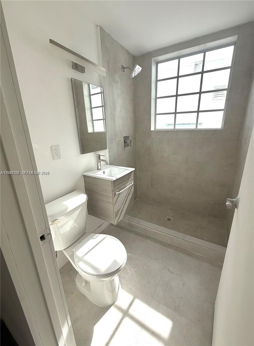 A small bathroom features a walk-in shower, a pedestal vanity, and a toilet — 1525 Euclid Ave # 4, Miami Beach FL 33139, MIAMI BEACH, FL