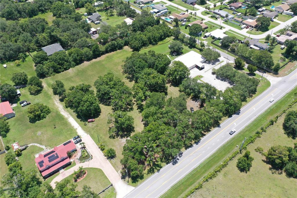 An aerial view shows a large, wooded lot with a house and a commercial building — 2351 CANOE CREEK ROAD, ST CLOUD, FL