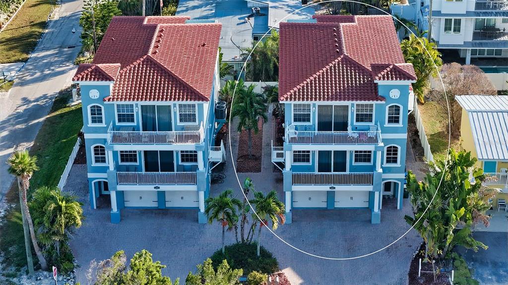 An aerial view of two blue, three-story residential buildings with red tile roofs — 2317 AVENUE C UNIT 300, BRADENTON BEACH, FL