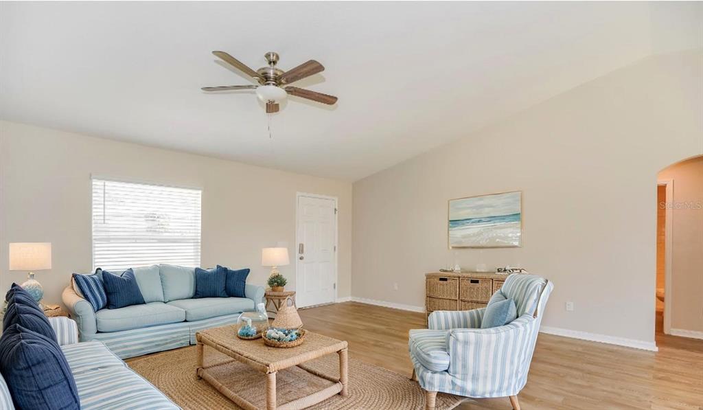 A living room features light wood floors, a vaulted ceiling, and coastal-themed furniture — 1958 W LINDEN DRIVE, CITRUS SPRINGS, FL