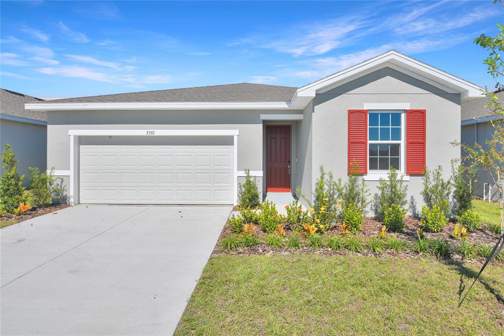 A single-story house with a gray stucco exterior, red shutters, and a two-car garage — 5351 MICKEY AVENUE, WINTER HAVEN, FL
