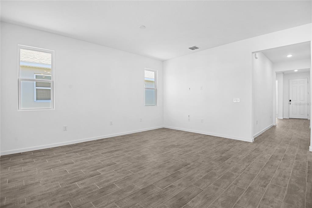 An empty room with white walls, gray tile flooring, and two windows — 5351 MICKEY AVENUE, WINTER HAVEN, FL