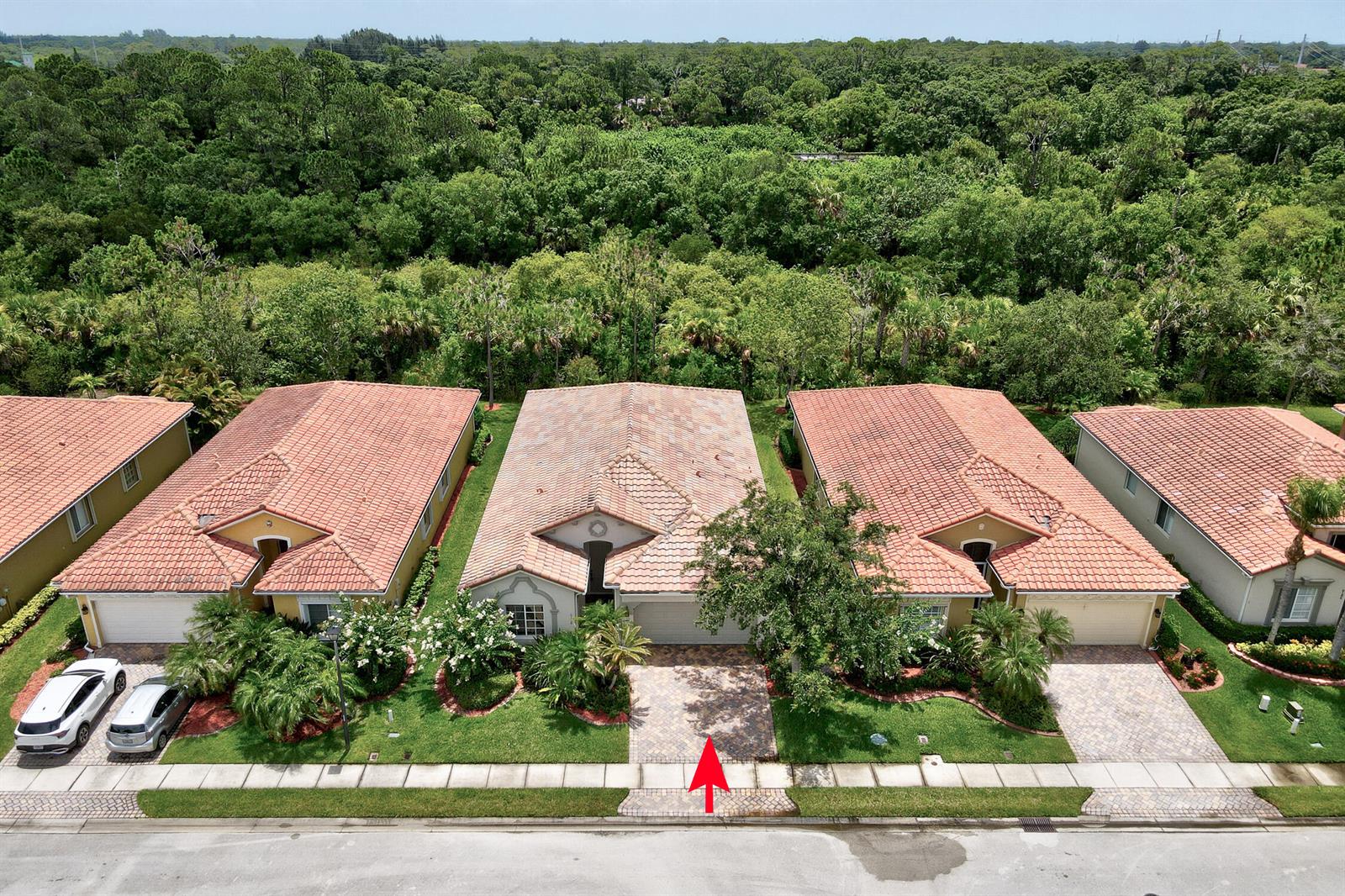An aerial view shows a row of suburban houses with tile roofs and paved driveways — 6188 Dorchester Way, Vero Beach FL 32966, VERO BEACH, FL