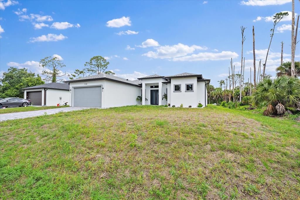 A single-story white house with a gray garage and a grassy front yard — 17328 ORION AVENUE, PORT CHARLOTTE, FL