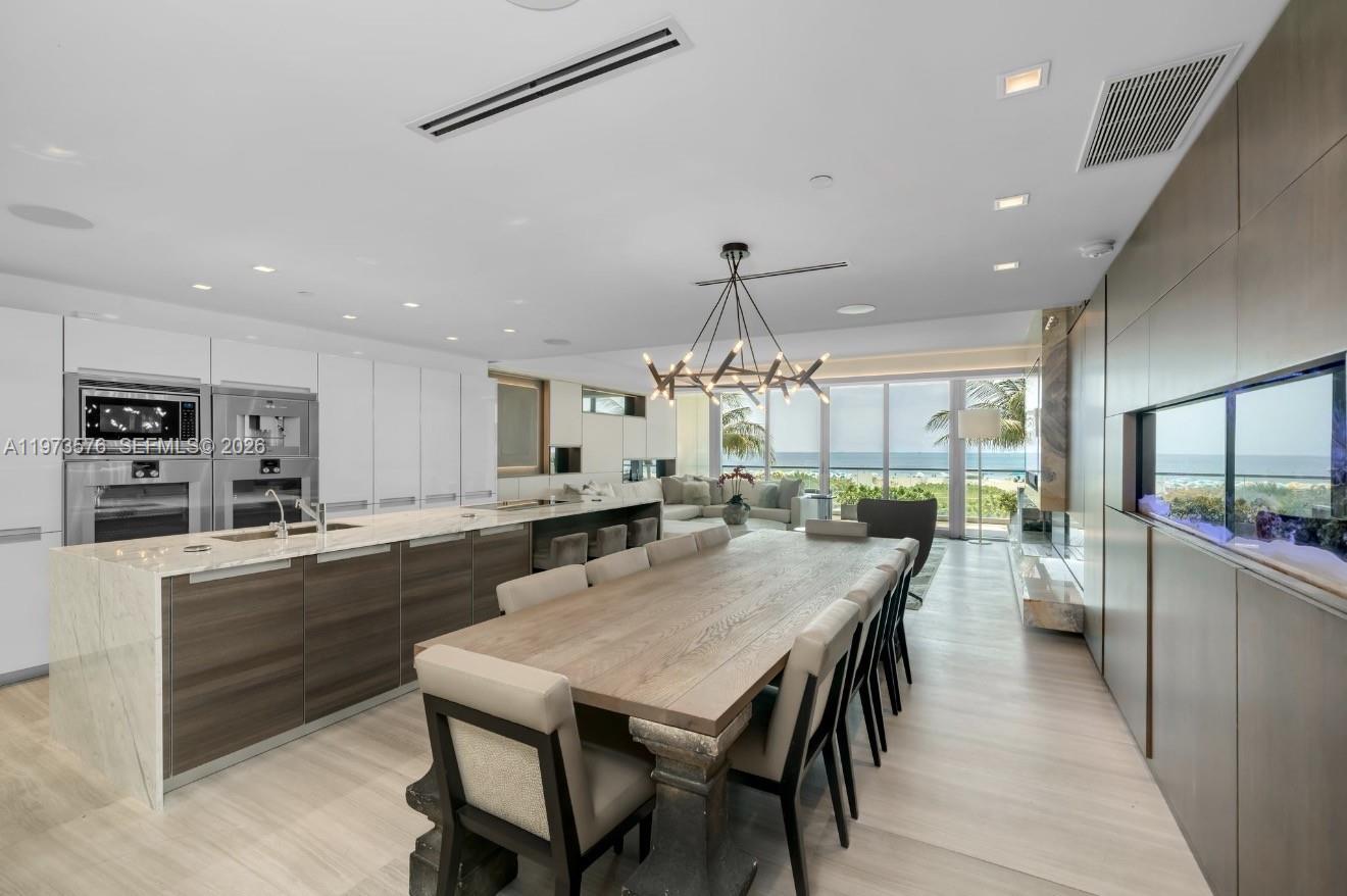 A modern open-concept kitchen and dining area features a large island and ocean views — 321 Ocean Dr # 200, Miami Beach FL 33139, MIAMI BEACH, FL