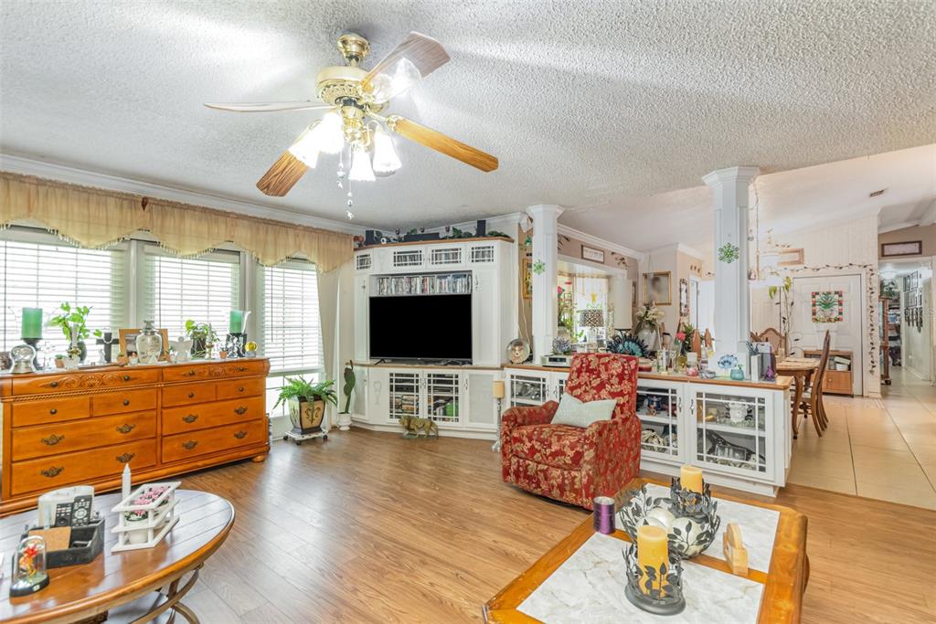 A living room features wood-look flooring, a ceiling fan, a television console, and a recliner — 1121 CLARK BAY ROAD, DELAND, FL