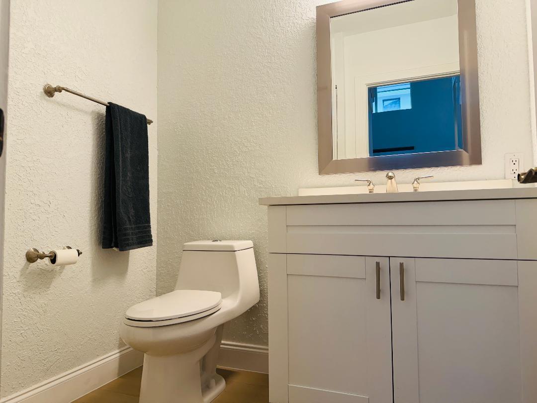A bathroom features a white vanity, a toilet, a wall-mounted towel rack, and a mirror — 5855 NW 42nd Way, Boca Raton FL 33496, BOCA RATON, FL