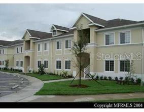 A multi-story apartment building with beige stucco walls and a parking lot in front — 6431 CYPRESSDALE DRIVE UNIT 202, RIVERVIEW, FL