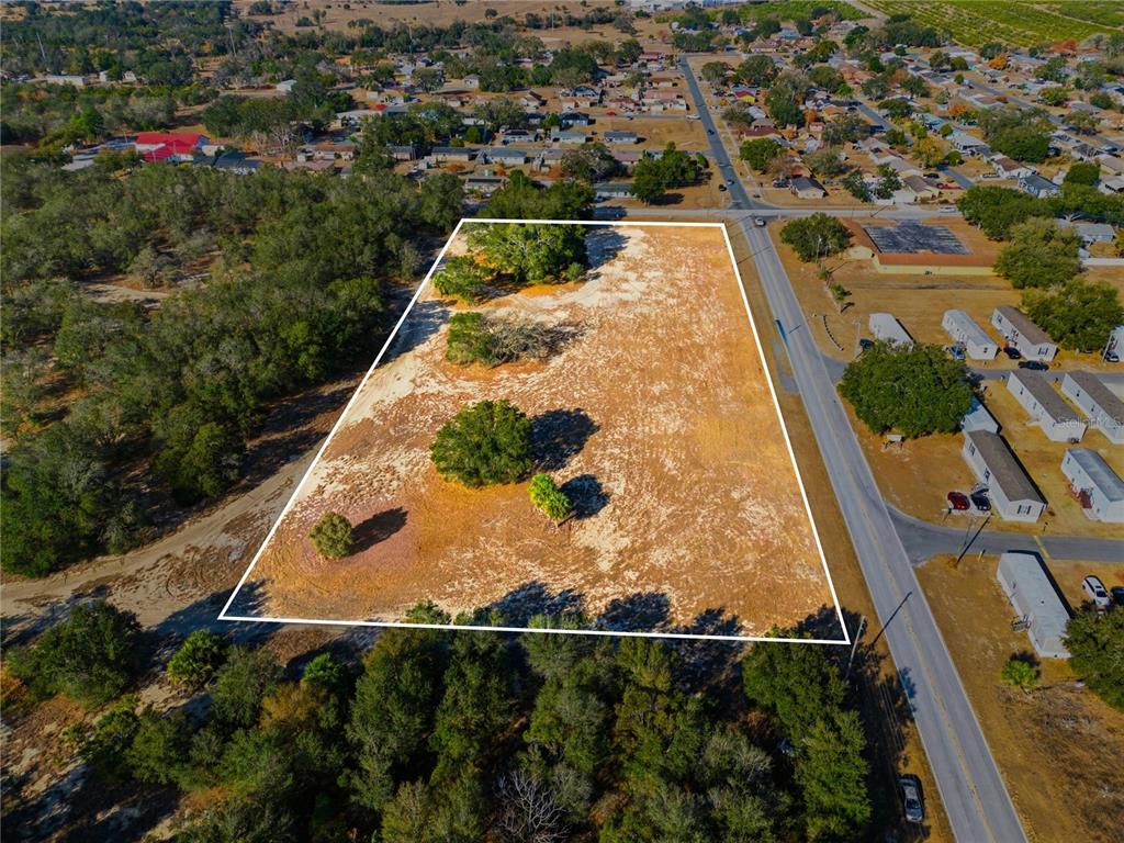 An aerial view shows a vacant, rectangular lot with scattered trees bordered by a road — FRIEDLANDER ROAD, LAKE WALES, FL