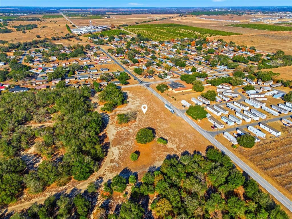 This aerial view shows a vacant, grassy lot situated next to a road and residential area — FRIEDLANDER ROAD, LAKE WALES, FL