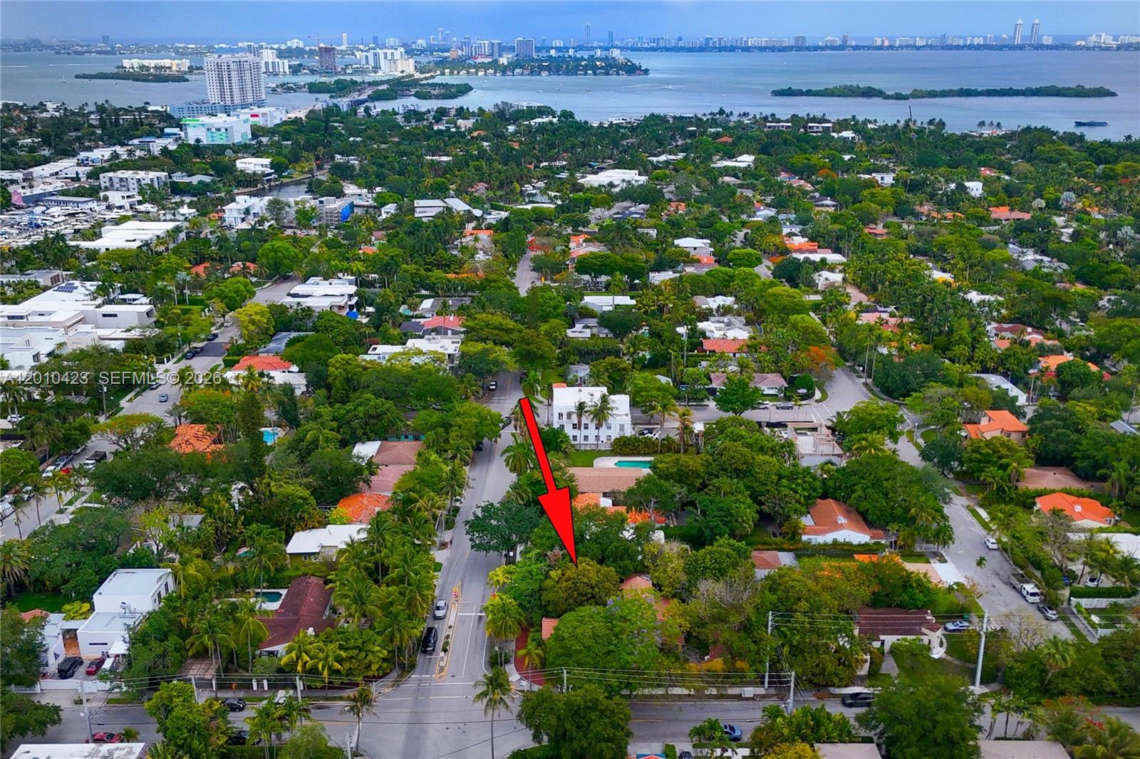 An aerial view shows a residential neighborhood with a red arrow pointing toward a house — 650 NE 76th St, Miami FL 33138, MIAMI, FL