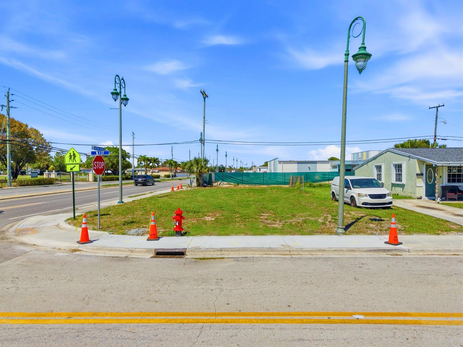 A vacant grassy lot sits on a corner with a fire hydrant and street lamps — 0 Australian Avenue, Riviera Beach FL 33404, RIVIERA BEACH, FL