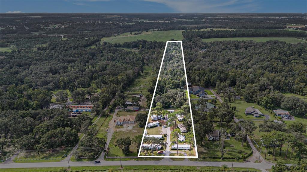 An aerial view shows a trapezoidal lot containing several mobile homes and wooded land — 14638 TREELEAF LANE, DADE CITY, FL