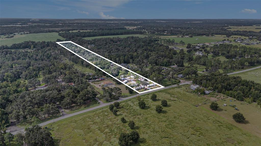 An aerial view shows a long, rectangular property outlined in white amidst a rural landscape — 14638 TREELEAF LANE, DADE CITY, FL