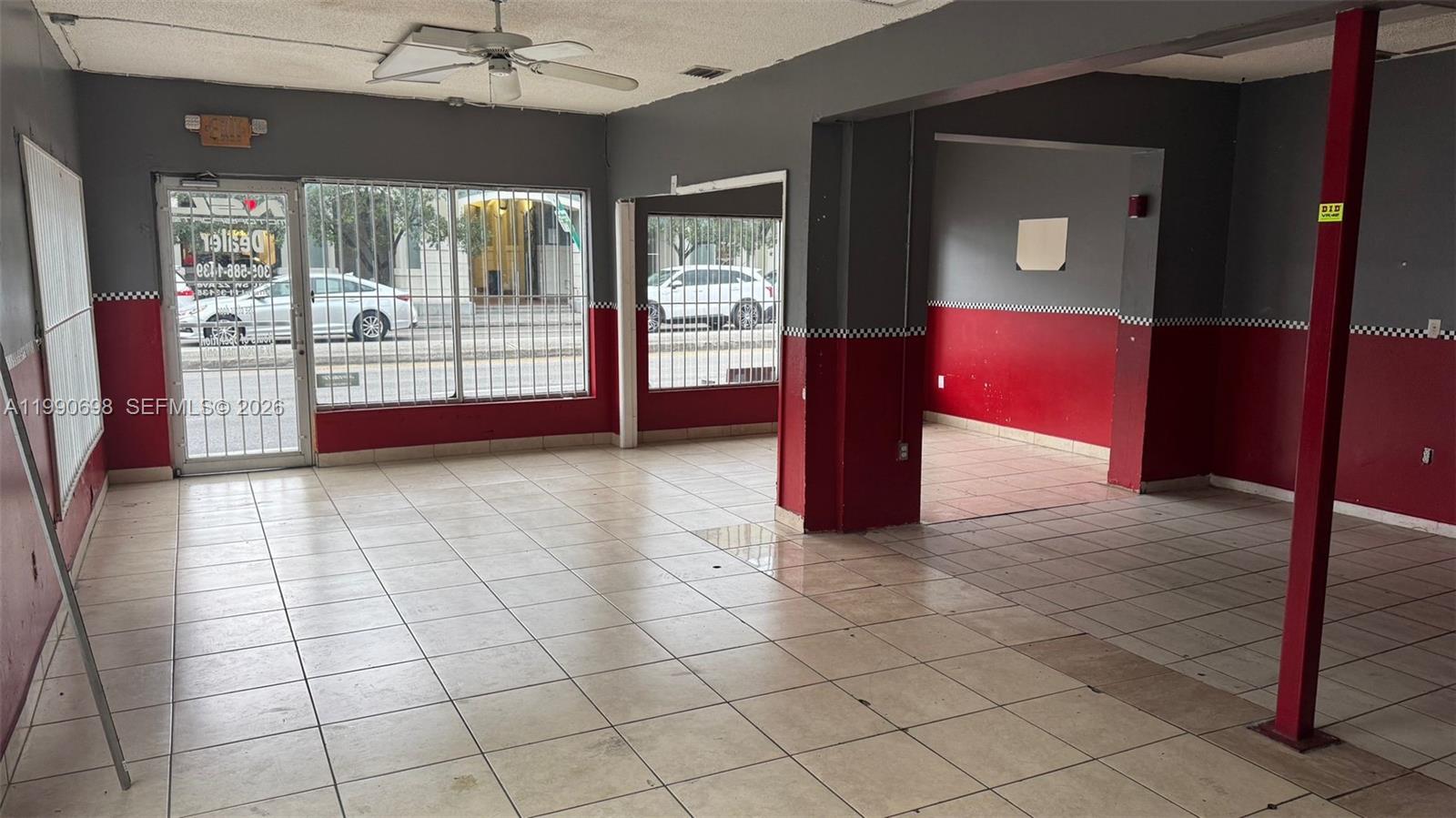 An empty commercial space features tiled floors, grey and red walls, and large windowed storefronts — 210 SW 22nd Ave, Miami FL 33135, MIAMI, FL