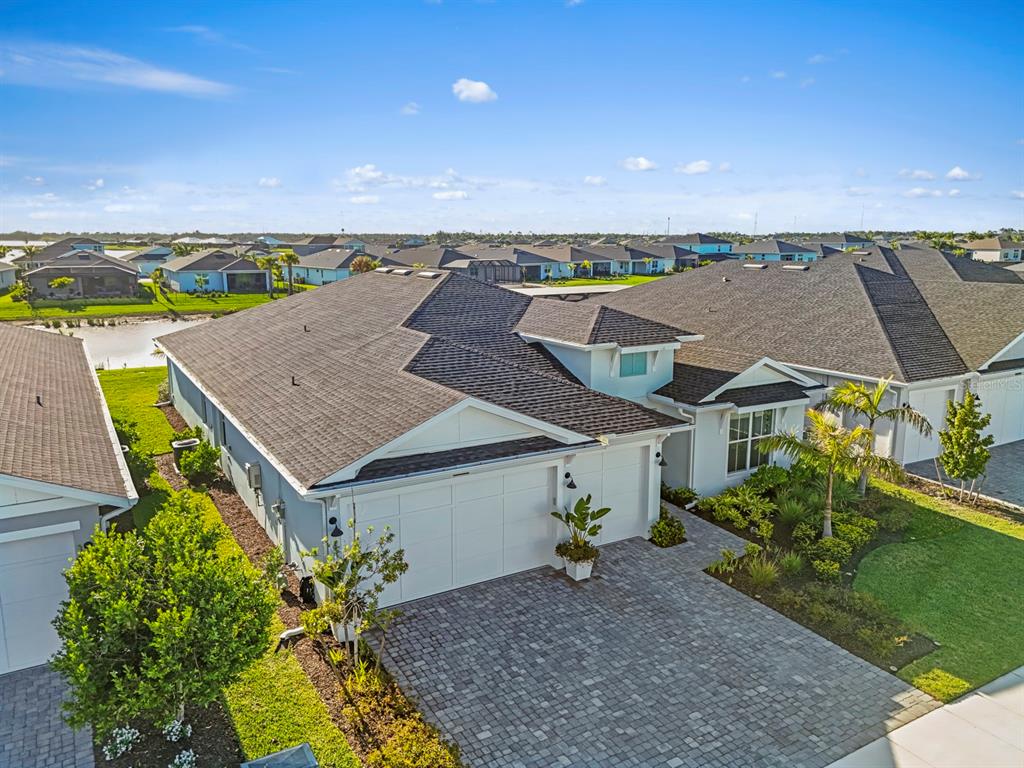 An aerial view shows a suburban house with a paved driveway and a shingled roof — 16261 PRESERVATION BOULEVARD, PUNTA GORDA, FL