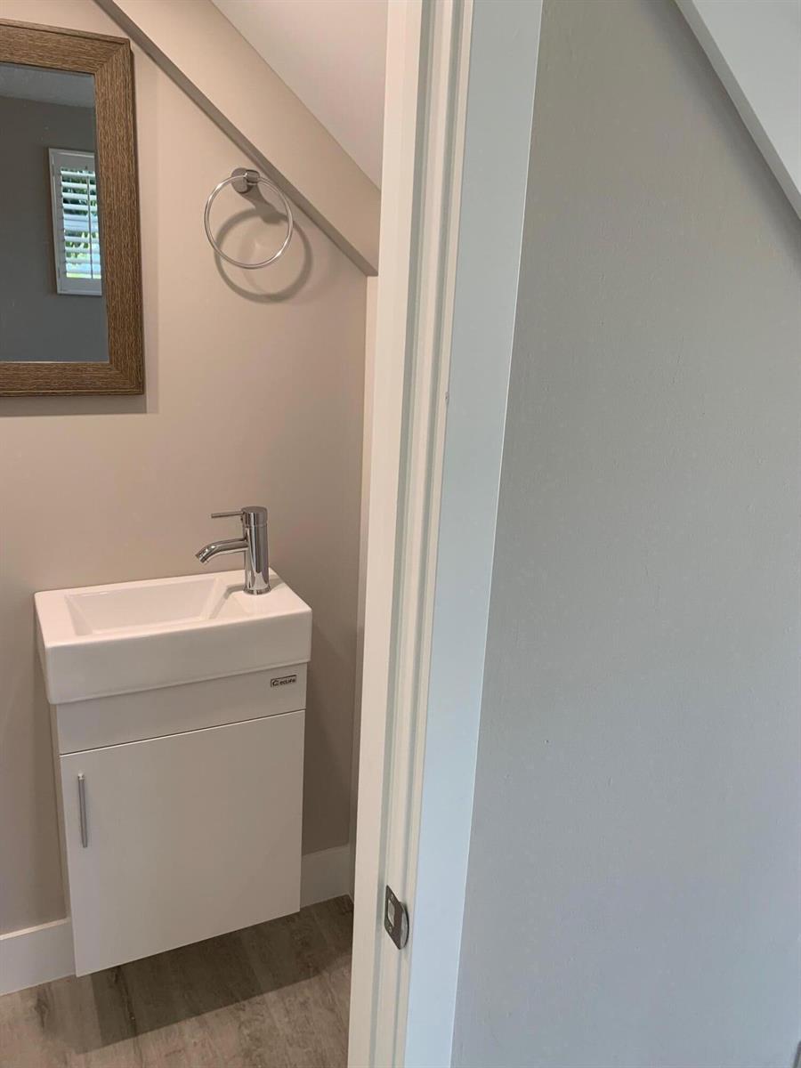 A small bathroom features a white vanity with a sink, a mirror, and a towel ring — 4220 NE Indian River Dr. Drive # 2, Jensen Beach FL 34957, JENSEN BEACH, FL