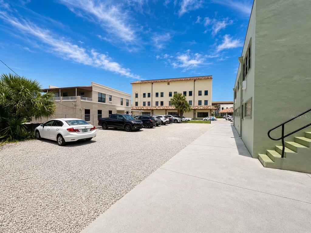 A gravel parking lot sits between two buildings under a bright blue sky — 117 N 5TH STREET, FORT PIERCE, FL