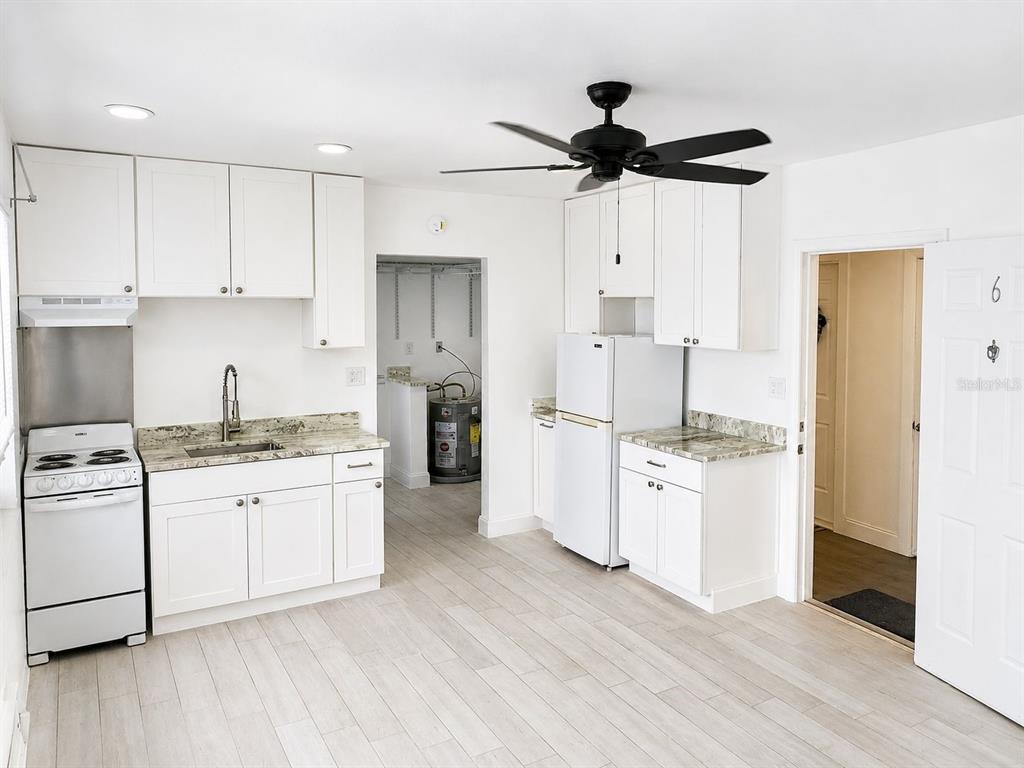 A kitchen features white cabinets, granite countertops, a white stove, and a white refrigerator — 117 N 5TH STREET, FORT PIERCE, FL
