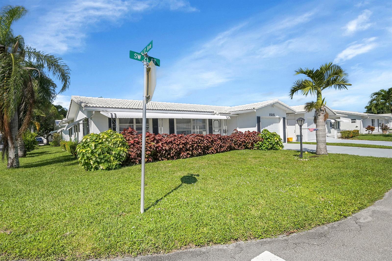A white single-story house with a tiled roof sits on a corner lot with landscaping — 1515 SW 21st Street, Boynton Beach FL 33426, BOYNTON BEACH, FL