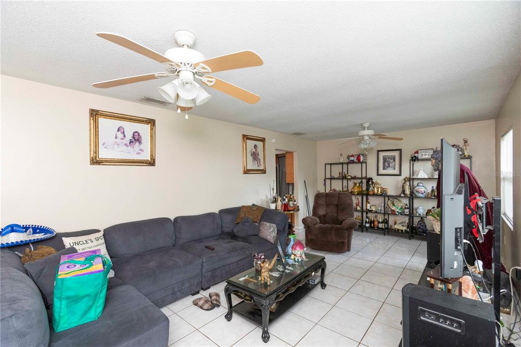 A living room features a grey sectional sofa, a coffee table, and a ceiling fan — 841 BRENTWOOD DRIVE, LAKE WALES, FL