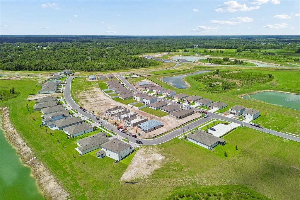 An aerial view shows a suburban neighborhood with newly constructed houses and several retention ponds — 4369 LAKE FOX DRIVE, LAKELAND, FL