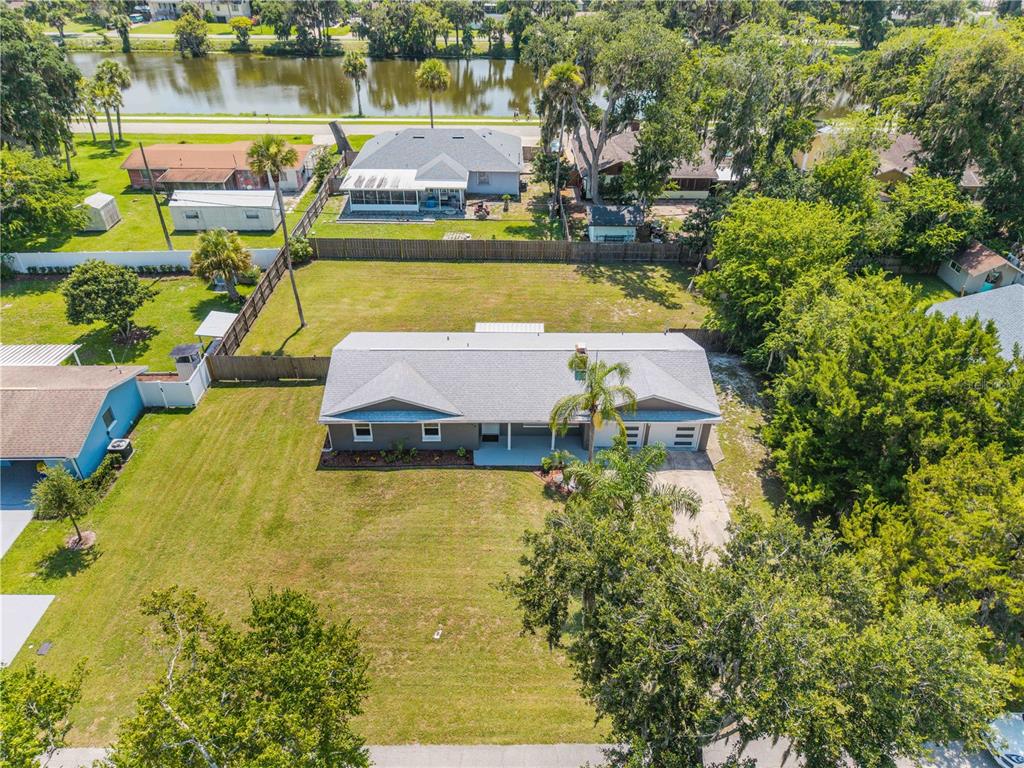 An aerial view shows a single-story house with a large front yard and backyard — 2716 KUMQUAT DRIVE, EDGEWATER, FL