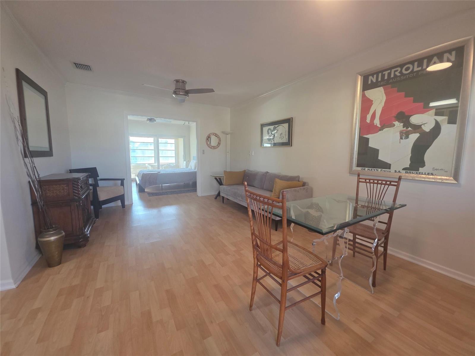 A living and dining area with light wood floors, a glass table, and a sofa — 2131 NE 42nd Court # 208e, Lighthouse Point FL 33064, LIGHTHOUSE POINT, FL