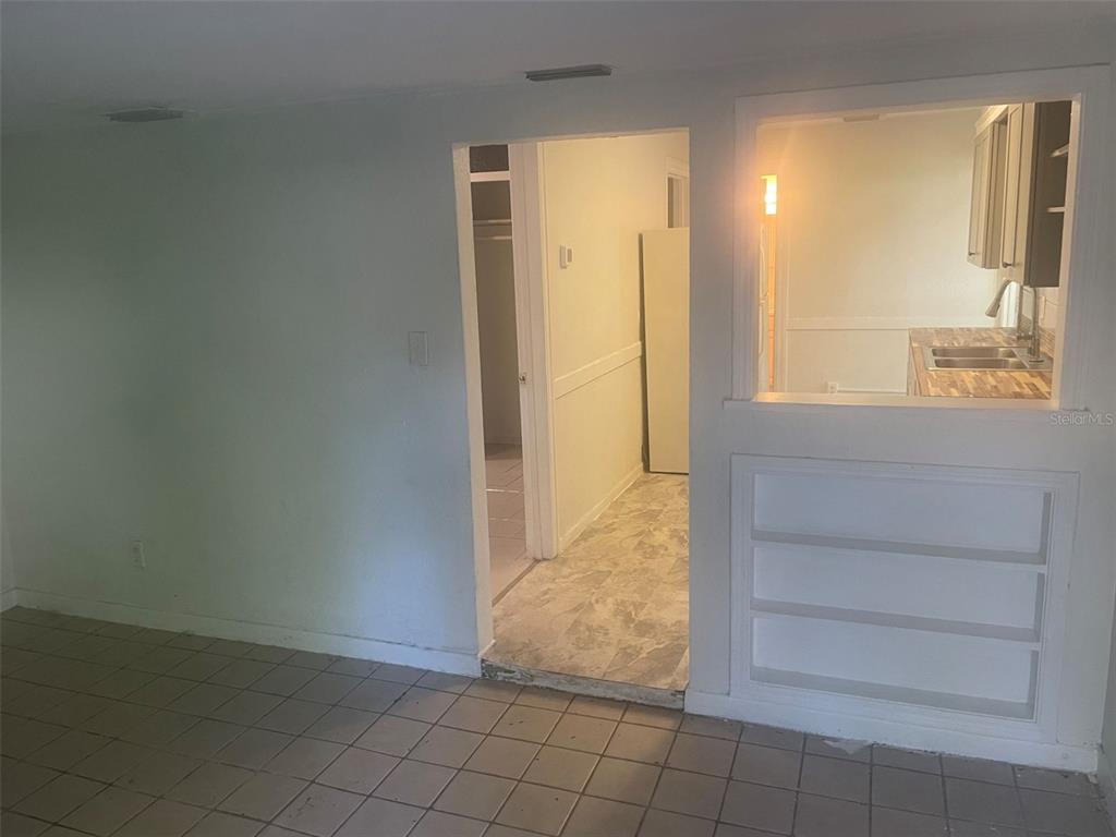 A view from a tiled room looking through a doorway into a kitchen area — 776 27TH AVENUE N UNIT 2, ST PETERSBURG, FL