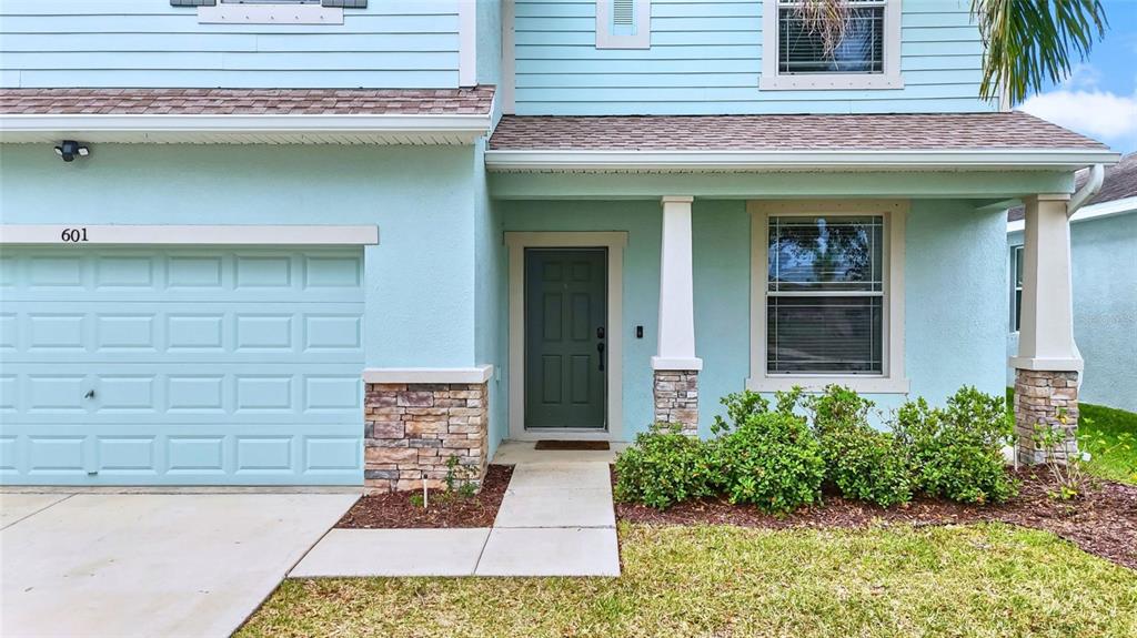 The exterior of a light blue two-story house features a garage and a front porch — 601 19TH STREET NW, RUSKIN, FL