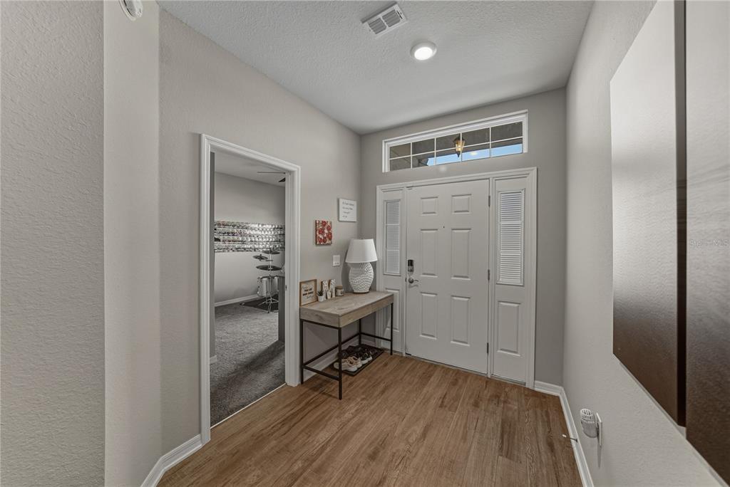 An entryway features wood-look flooring, a white front door with a transom window, and console — 929 MONTGOMERY LANE, POLK CITY, FL