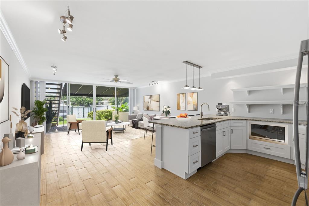 A bright, open-concept kitchen and living area with tile flooring and a waterfront patio view — 2424 W TAMPA BAY BOULEVARD UNIT G104, TAMPA, FL
