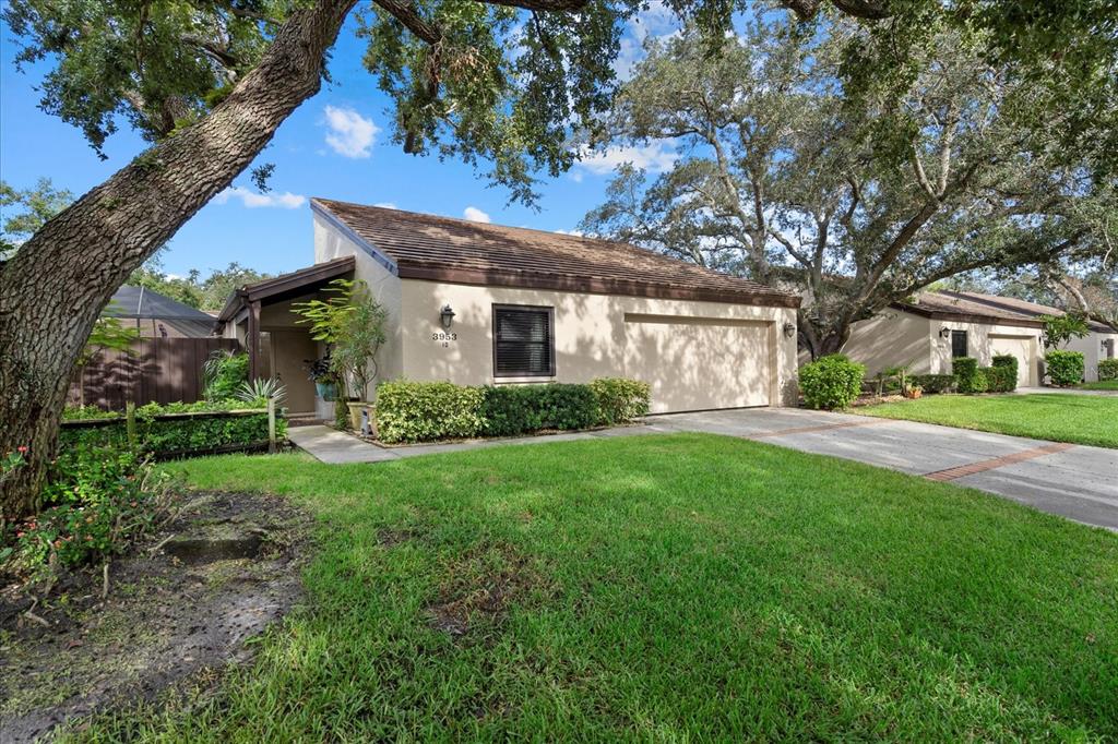 A single-story house with a tan exterior, a garage, and a large tree in front — 3953 GLEN OAKS MANOR DRIVE, SARASOTA, FL