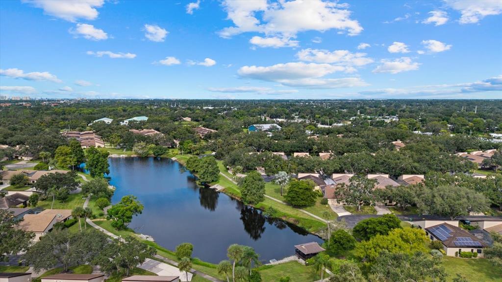 An aerial view shows a residential community with houses surrounding a central lake — 3953 GLEN OAKS MANOR DRIVE, SARASOTA, FL