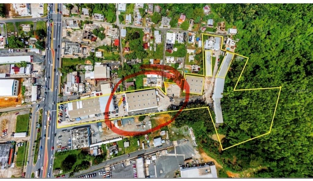 An aerial view shows a commercial property with warehouses and surrounding land outlined in yellow — Carr #2 KM 17.0, TOA BAJA, PR